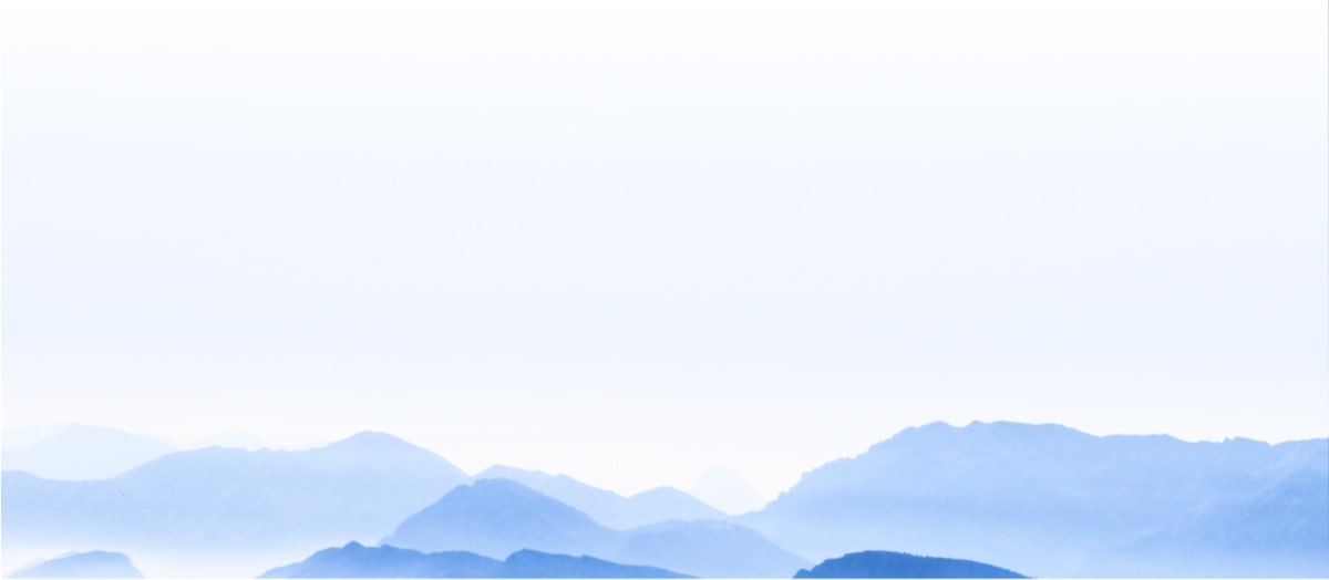 Background image showing blue-grey mountains in the far distance.